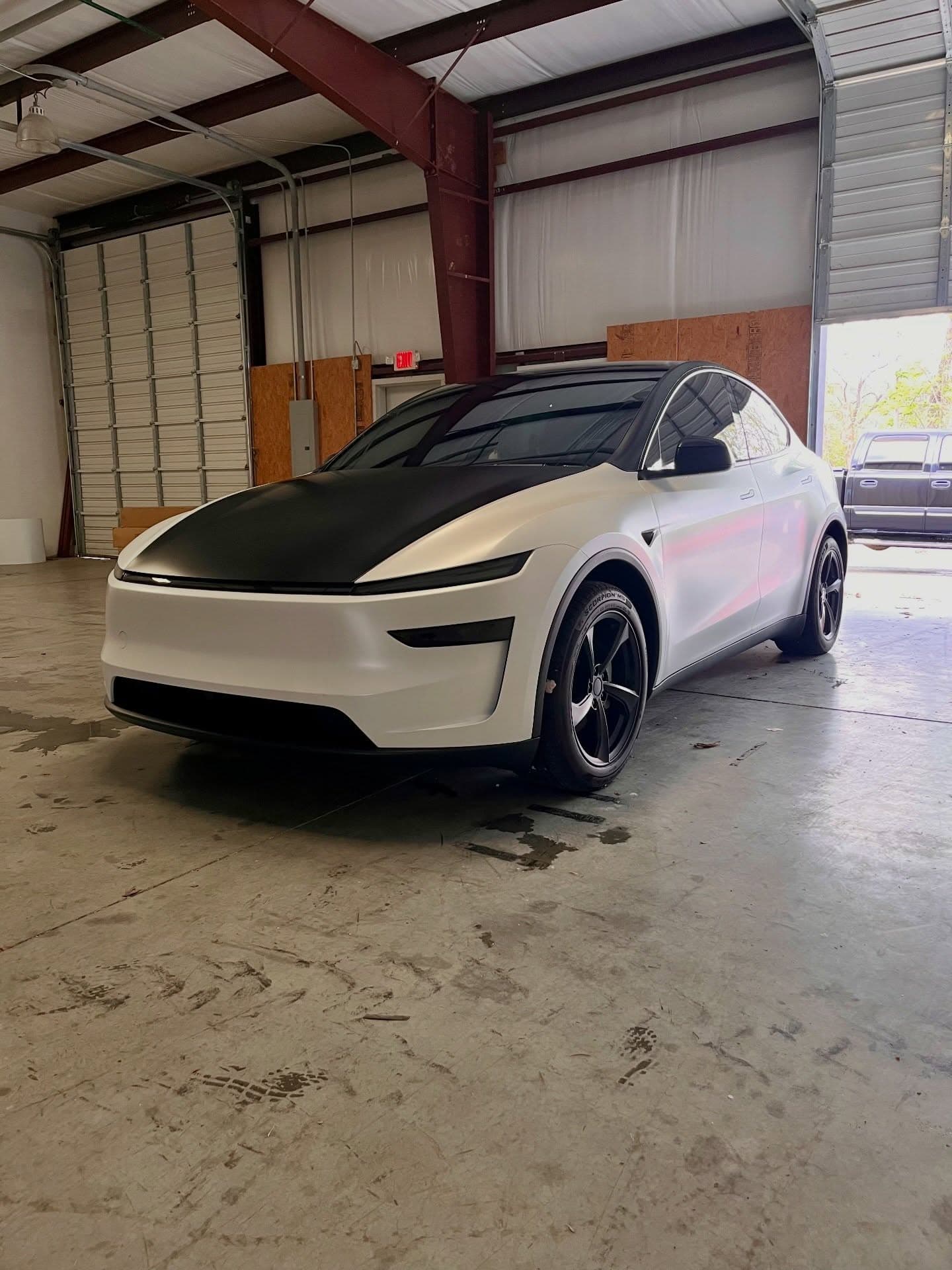 Freshly detailed white Tesla Model Y exterior in a Cumming, GA shop bay